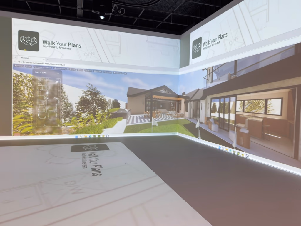 A photorealistic 3D exterior rendering of a custom home projected across the Walk Your Plans NWA studio walls