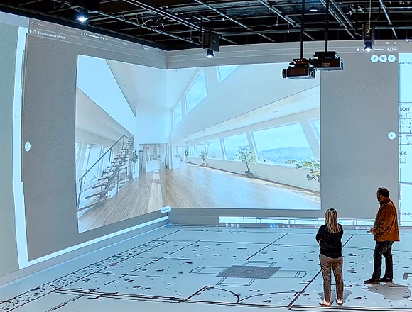 A 3D architectural rendering and floor plan projected at full scale on the Walk Your Plans NWA studio wall